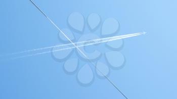 The track behind the airplane in the cloudless blue sky. Cable crosses the image in the foreground