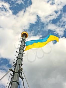 Flag of Ukraine hanging on the flagstaff and waving in the wind, installed on the City Hall of Lviv, Ukraine