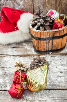 Decorative wooden tub filled with Christmas ornaments and pine cones