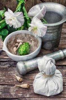 Stems of herbaceous medicinal plants genus Datura Nightshade family with poppy seeds on the background mortar with pestle.