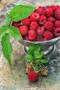 Plucked raspberries in vintage iron ramekin.Photo tinted.