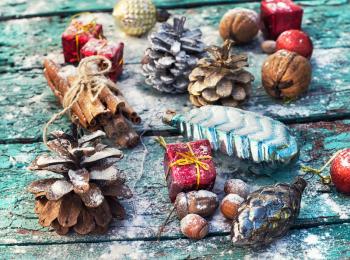Gifts and decorations for Christmas on wooden background strewn with pine cones and spices