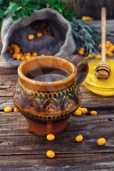 Clay mug with medicinal decoction of sea buckthorn and honey