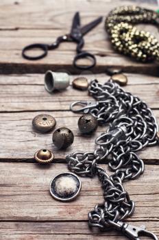 metal chain and beads for craft on wooden background