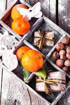 Decorative wooden box with hazelnuts,mandarins and gifts.