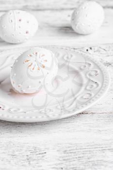 Decorative carved chicken egg for Easter to light the plate.Photograph high key.