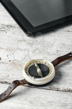 old compass and tablet PC on bright wooden background