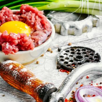 Dish of raw minced beef meat and parts of meat grinder