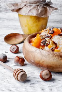 Porridge with pumpkin in a stylish wooden bowl, rustic