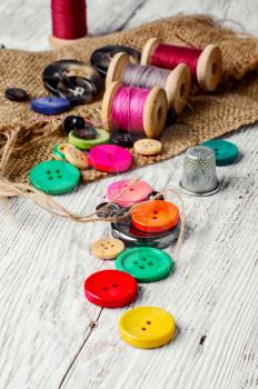 Set of several pied buttons for garment with threads on a bright background