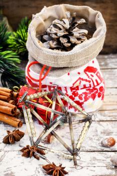 Pine and pinecone Christmas decorations on snowy wooden background