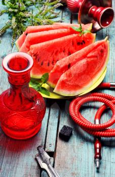 Still life with slices of ripe watermelon and smoking hookah