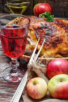 Whole baked chicken with apples and stylish glass of red wine