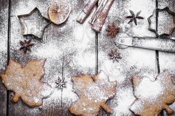 Spicy cookies in the form of maple leaves on the snow-covered wooden background