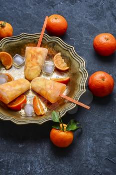 Tasty ice cream with tangerines in copper dish
