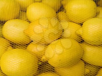 A pile of beautiful lemons in the grid on a counter