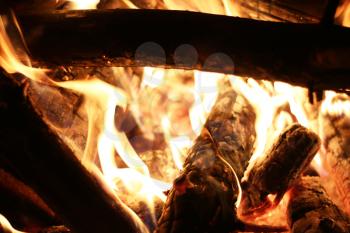 Closeup log fire in night fireplace. Burning flame. Barbecue coal blazing
