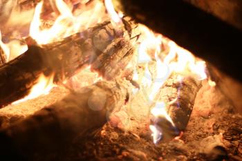 Burning big log fire in night fireplace. Closeup flame. Barbecue coal blazing