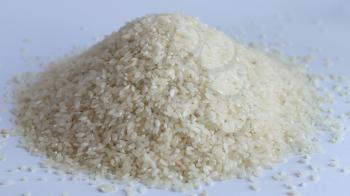 Pile of rice or wholegrain spill on white background. Agriculture food raw seed. Closeup macro photo
