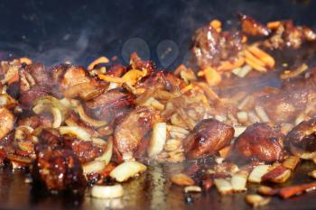 Hot cook meat onion carrot vegetable in smoke fry on cauldron pan. The stage of cooking pilaf