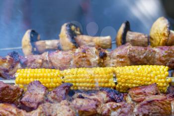 Barbecue shish kebab cook. Tasty grill corn and mushroom champignon dinner cooking. Food BBQ background. Roasted fresh beef meat