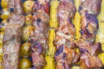Barbecue kebab cooking. Tasty grill corn and potatoes dinner cooking. Food BBQ background. Roasted fresh beef meat