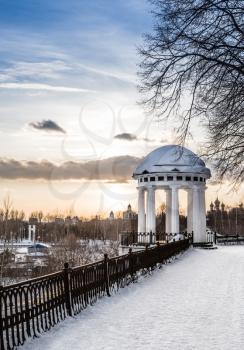 Arbor on the quay in the heart of city. Spring snowy evening. Russia, Yaroslavl.