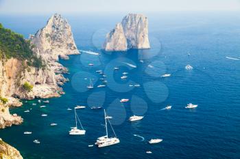 Capri island, Italy. Mediterranean Sea, coastal landscape with Faraglioni rocks and pleasure boats