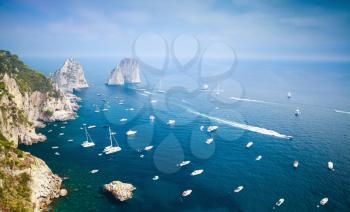 Capri island, Italy. Mediterranean Sea, coastal landscape with Faraglioni rocks and pleasure yachts