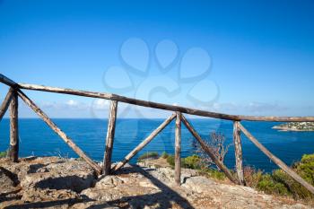 Wooden railing on rocky coast of Mediterranean sea, Gaeta, Italy