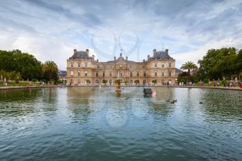 Paris, France - August 10, 2014: Luxembourg Palace and reflection in the pond with fountain. Luxembourg Garden in Paris