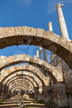 Empty corridor with arcs and columns above blue sky backgroud. Ruins of Ancient city Smyrna. Izmir, Turkey