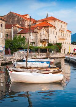 Wooden boats float moored in Perast. Kotor Bay, Montenegro