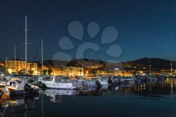 Pleasure yachts and motor boats moored in old port of Ajaccio, the capital of Corsica island, France. Dark night photo