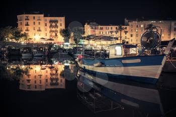 Wooden fishing boat moored in old port of Ajaccio, the capital of Corsica island, France. Night photo with warm tonal correction filter