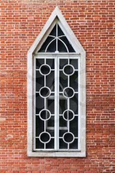 Window in red brick wall, Gothic Revival architecture style. Background texture