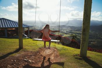 Little girl swinging on a swing. Montana Redonda. Dominican Republic