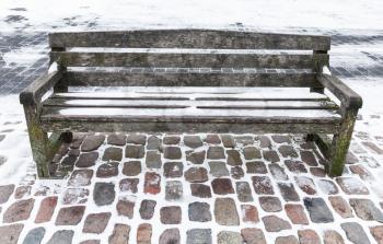 Empty wooden bench covered with snow in winter park. Saint-Petersburg, Russia
