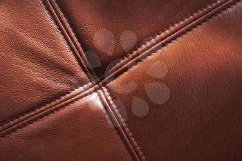 Brown genuine leather with seams, background texture, close up photo