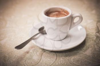 Small white cup of espresso coffee, vintage stylized photo