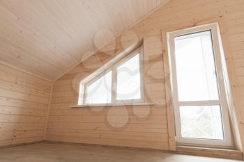 Empty wooden house interior, attic room with window and balcony door