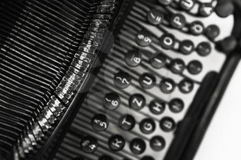 Old manual typewriter machine, closeup fragment with letters and keys, black and white photo with soft selective focus