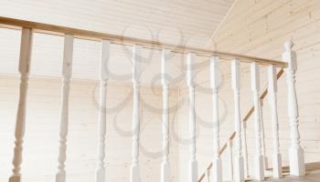 White balusters, balcony railings. Empty wooden house interior