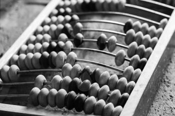 Old abacus lay on stone table, close up black and white photo with selective focus