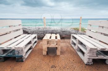 Standard wooden furniture made of cargo pallets, cheap seaside terrace on Porto Santo island, Madeira archipelago, Portugal
