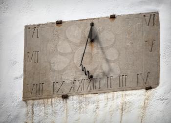 Ancient sundial with signs of the zodiac on white church wall in Tallinn, Estonia