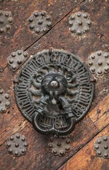 Ancient weathered door fragment with metal lion head handle. Old part of Tallinn, Estonia