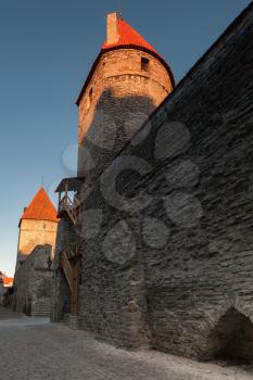 Dark fortress walls and towers in old town of Tallinn in the morning sunlight