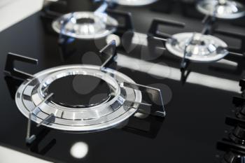 Modern gas stove burner made of shiny stainless steel and black ceramics