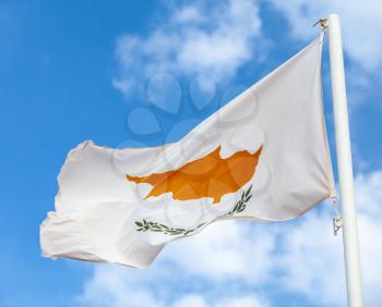 National flag of Cyprus waving on wind over cloudy blue sky